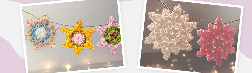 Banner mit gehäkelten Schneeflocken in mehreren Farben (blau, gelb, rosa, grün, weiß, pink) an einer Schnur vor warmen Lichterpunkten für Häkelanleitungen Schneeflocken häkeln